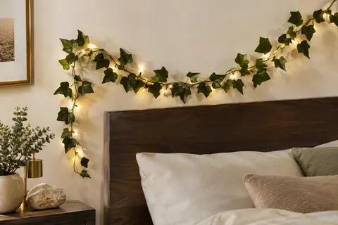 Guirlande de lierre artificiel de 2 m avec 20 petites LED blanc chaud disposée sur un mur ivoire.