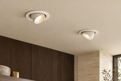 Deux spots encastrables blancs orientables au plafond, avec leurs têtes dirigées vers des zones différentes.