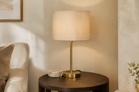 Lampe à poser Chao Zan avec base en métal et abat-jour en tissu sur une table d’appoint