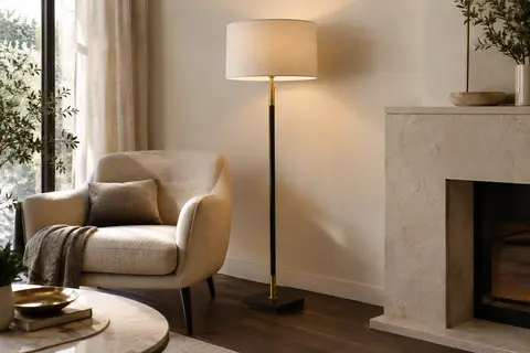 Lampadaire noir et doré à hauteur réglable, avec abat-jour en tissu dans un intérieur lumineux.