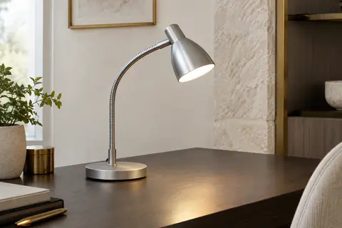 Lampe de bureau Velamp en métal argenté avec bras flexible, posée sur un bureau en bois fumé.