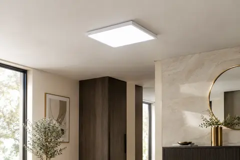 Plafonnier LED carré blanc et plat fixé au plafond dans une pièce aux murs ivoire.
