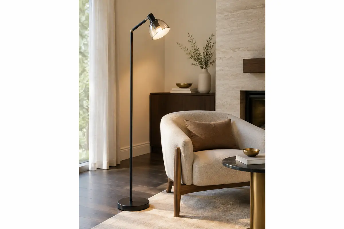 Lampadaire LED noir à tête orientable installé près d’un fauteuil dans un salon lumineux